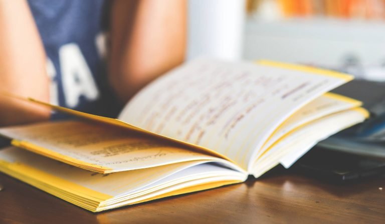 alt="A young child slouching at a school desk, highlighting the postural overload that can lead to back pain and fatigue in growing children."