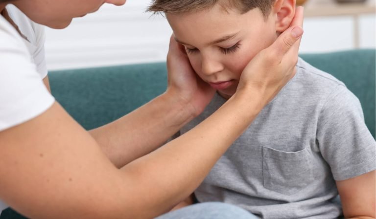 alt="Chiropractor performing a very gentle spinal check on a young child to support natural development and comfort."