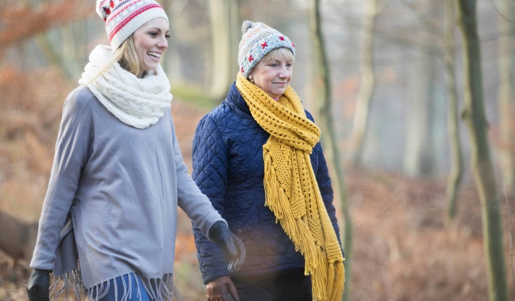 alt="A woman and her mother walking confidently, enjoying the mobility and balance gained from regular care."